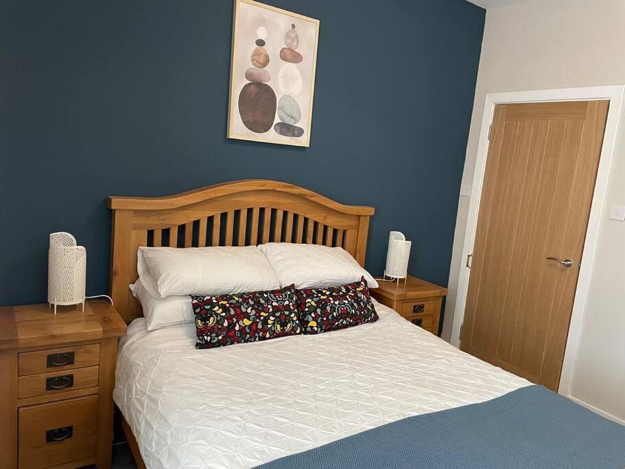 a bedroom with a bed and a blue wall at James St Park 2 bed Gr Flr, sleeps 4 in Helensburgh