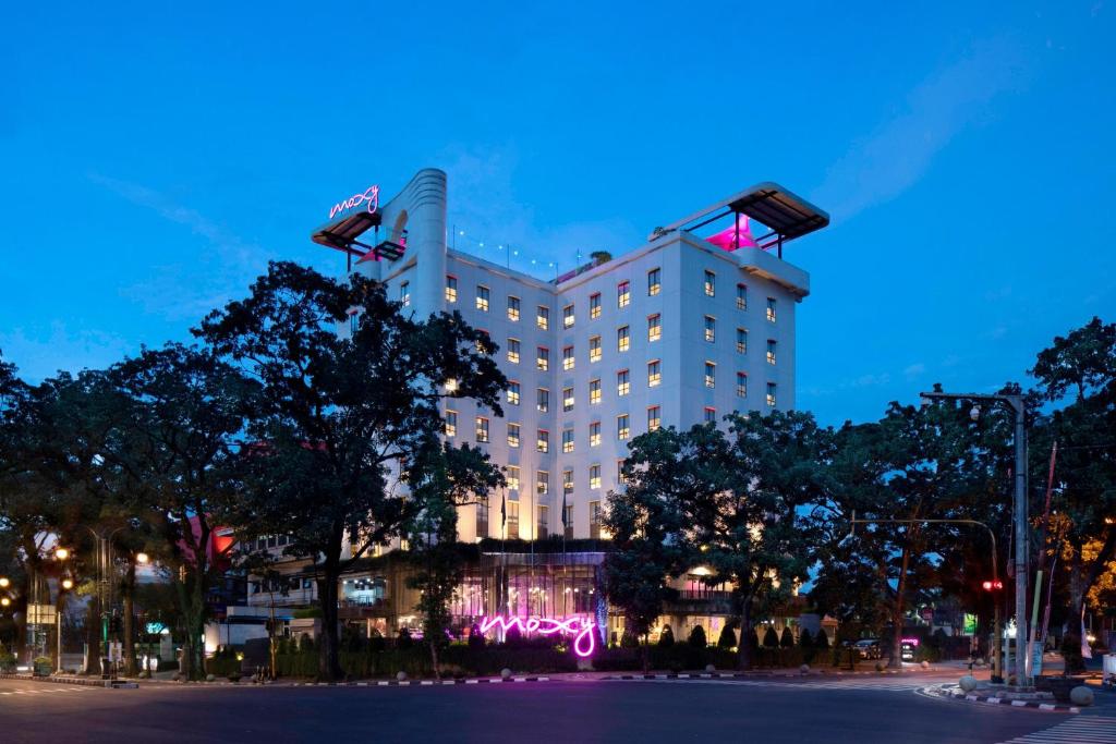 a hotel with a lit up facade at night at MOXY Bandung in Bandung