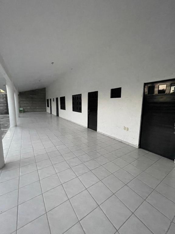 een lege kamer met zwarte deuren en een witte tegelvloer bij Hermosa Casa Campestre Para 12 Personas in Los Sauces