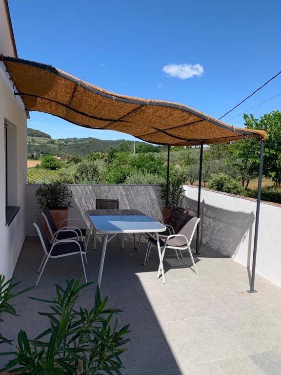 - une table et des chaises sous un parasol sur la terrasse dans l'établissement Terre de Lumière, à Nyons