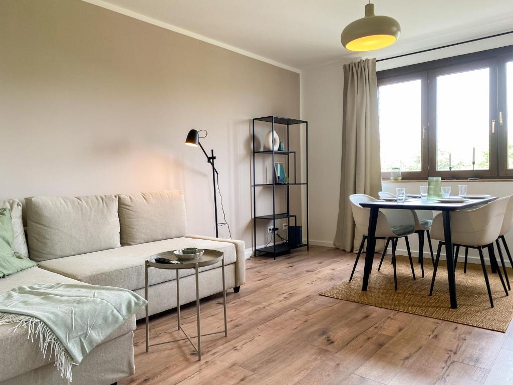 ein Wohnzimmer mit einem Sofa und einem Tisch in der Unterkunft Schöne Wohnung mit Rheinblick/Düsseldorf/Neuss/Messe in Neuss