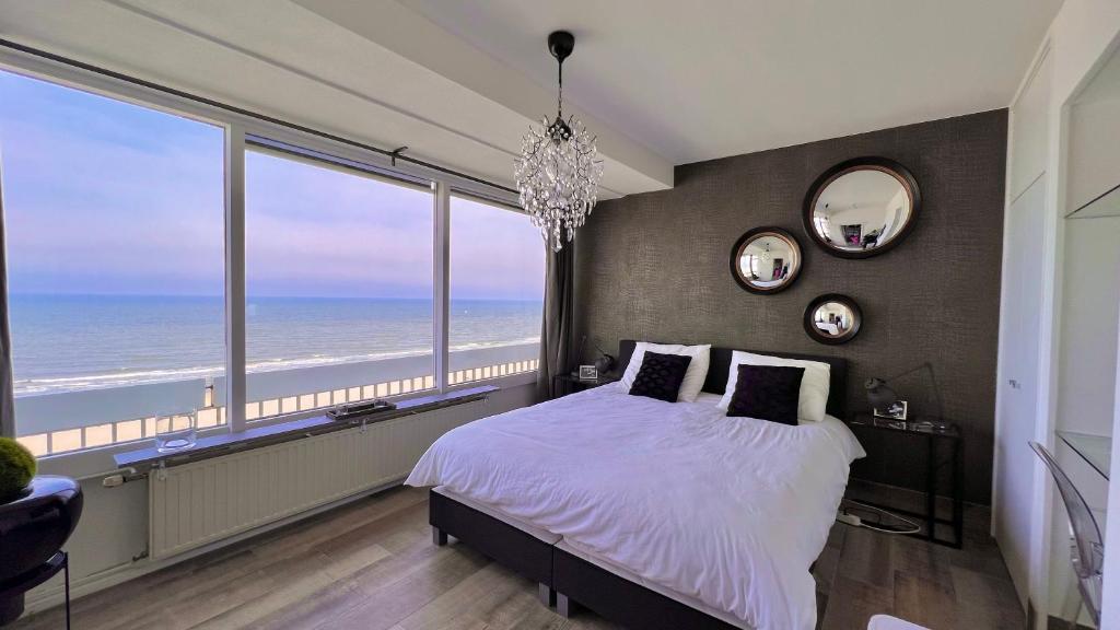 1 dormitorio con 1 cama y vistas al océano en Ocean BreezeApartment: WakeUp 2 Sound of the Waves en Zandvoort