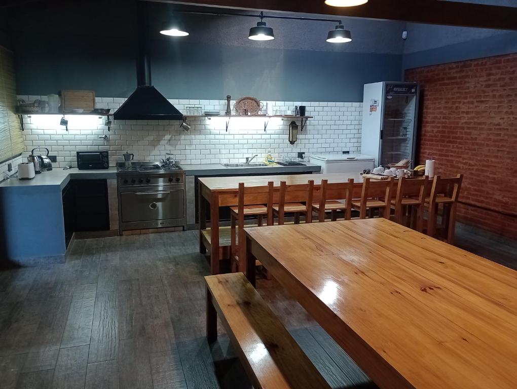 - une cuisine avec une table et des chaises en bois dans l'établissement Escala Ezeiza Loft con desayuno, à Luis Guillón