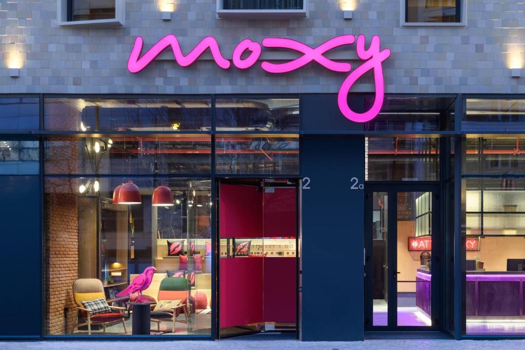 a pink neon sign on the front of a store at Moxy Lisbon City in Lisbon