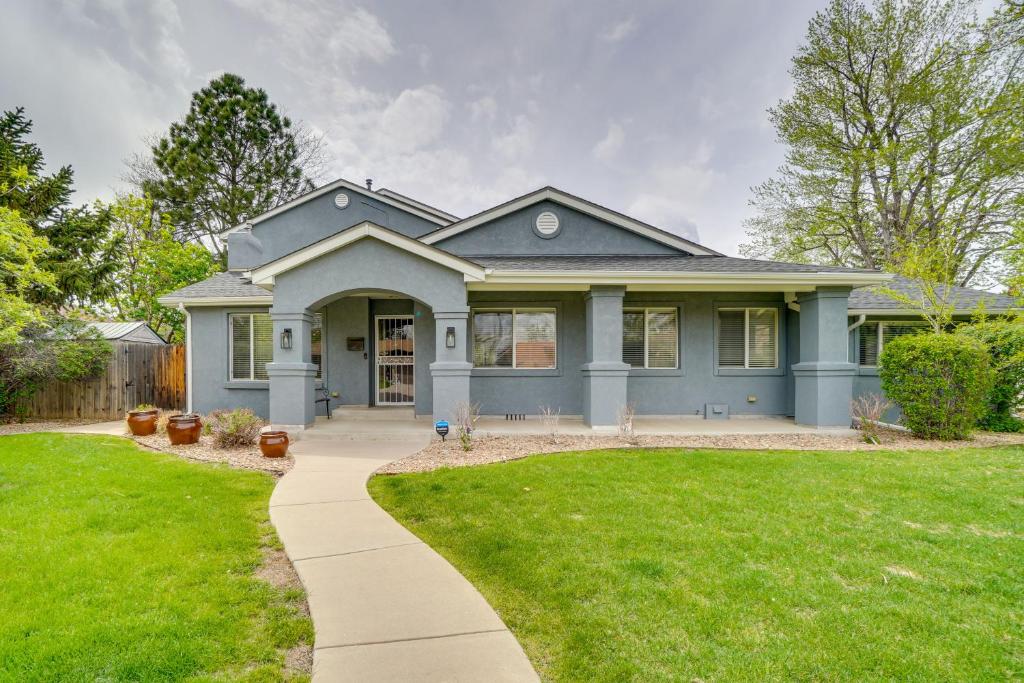 a blue house with a sidewalk in front of a yard at Dog-Friendly Denver Vacation Home with Gas Grill! in Denver