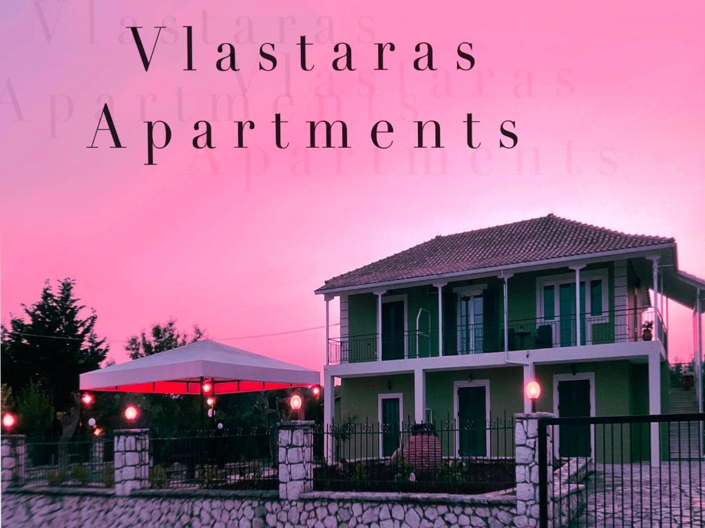 a house with a fence and a pink sky at Vlastaras Apartment in Sivota