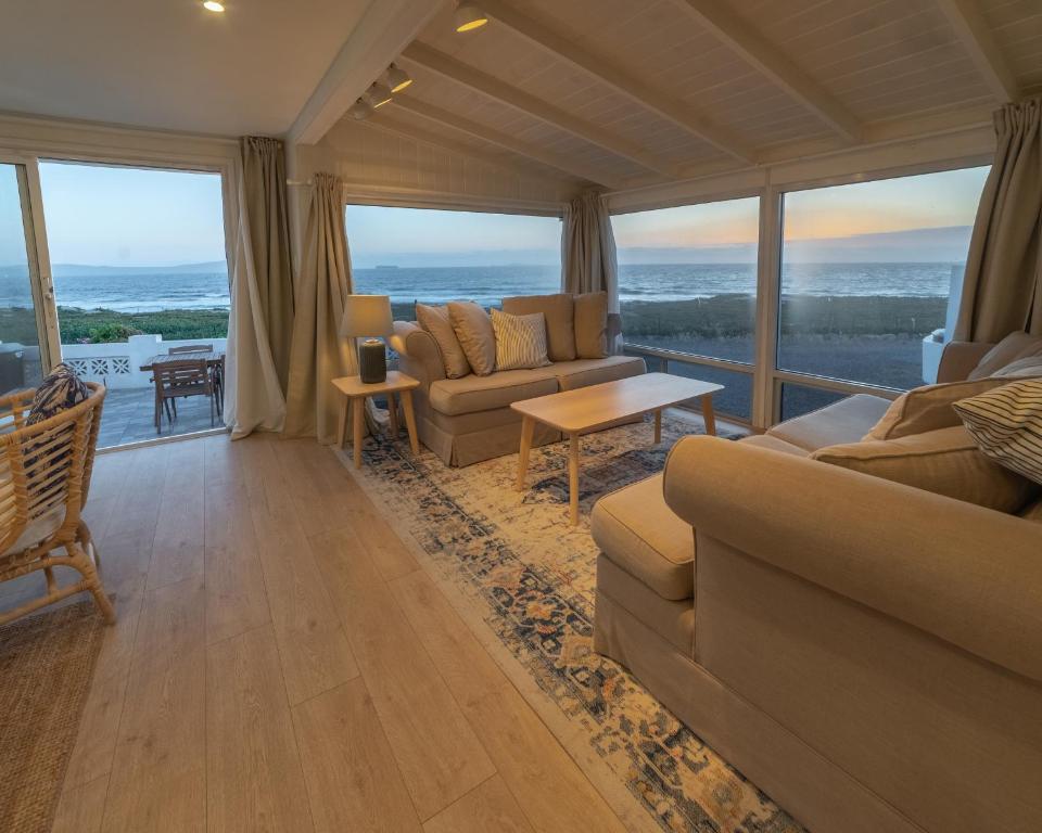 エンセナダにあるCASA MARIA - BEACHFRONT COTTAGE ON THE SANDのソファ付きのリビングルームが備わり、海の景色を望めます。