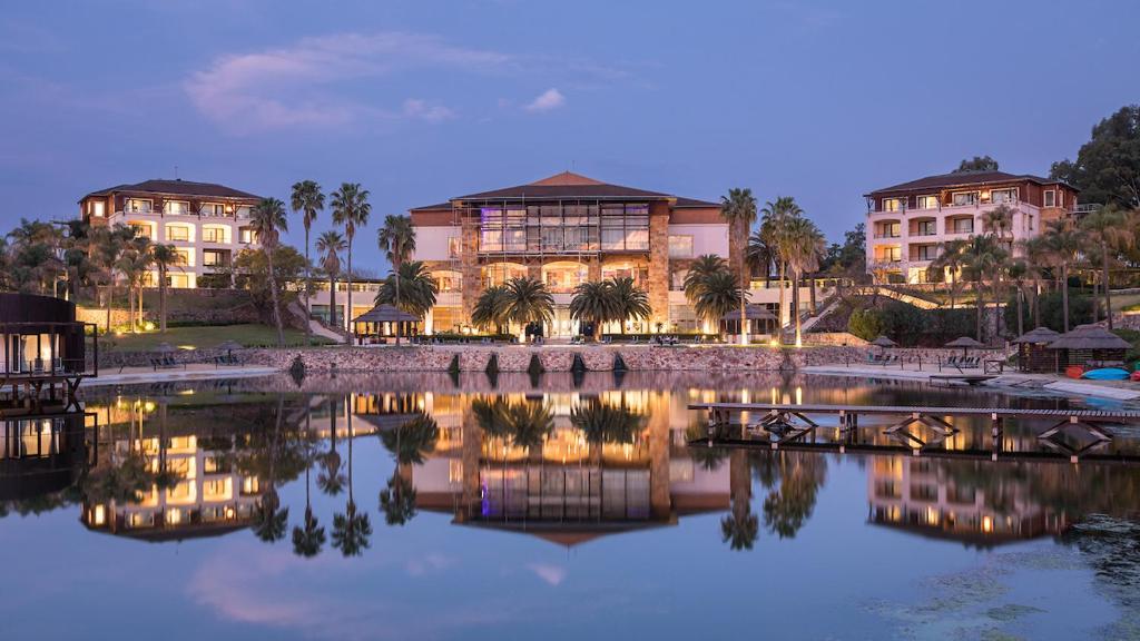a group of buildings next to a body of water at Sofitel La Reserva Cardales in Río Luján