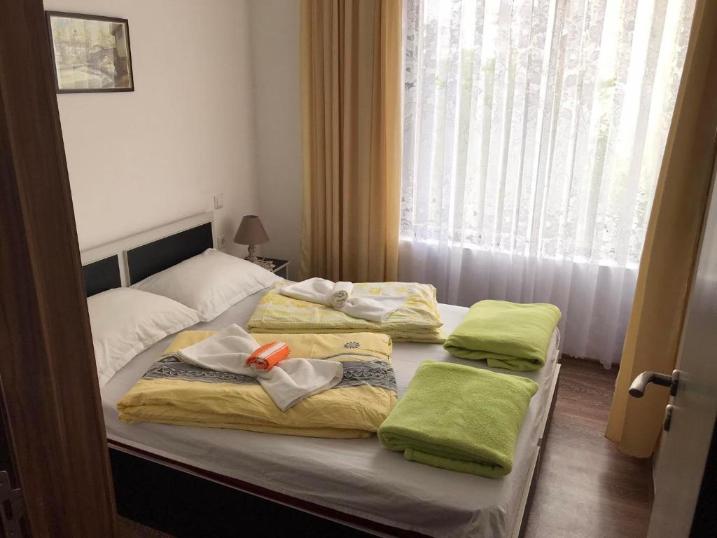ソゾポルにあるАпартамент Хармонияのベッドルーム1室(ベッド1台、緑のタオル付)