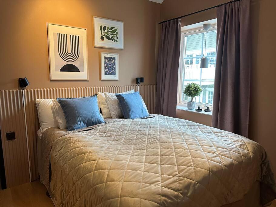 a bedroom with a bed with blue pillows and a window at Panoramavy nära Gbg och natur in Olofstorp