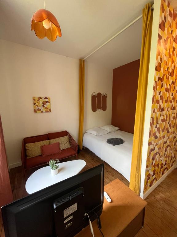 Cette petite chambre dispose d'une télévision et d'un lit. dans l'établissement L’appartement Le Mer’Ville, à Saint-Nazaire