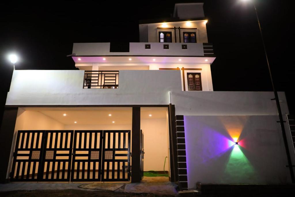 a white house at night with a light on it at JDP Villa 2 Bhk House in Ooty
