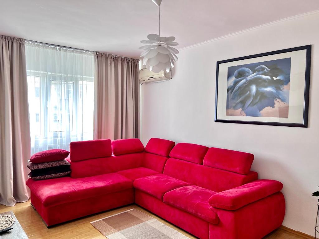 a red couch sitting in a living room at Cozy Apartment in Turnu Măgurele