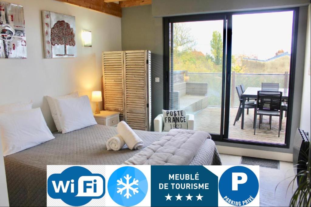 een slaapkamer met een bed en een balkon met een tafel bij Meuble prestige in Nancy