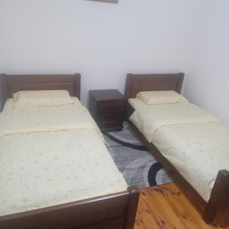 two twin beds in a room with wooden floors at Apartments Avramovic in Žabljak