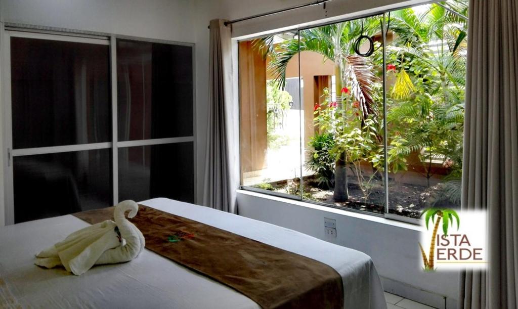 1 dormitorio con cama y ventana grande en Apartamento Vacacional Vista Verde, en Tarapoto