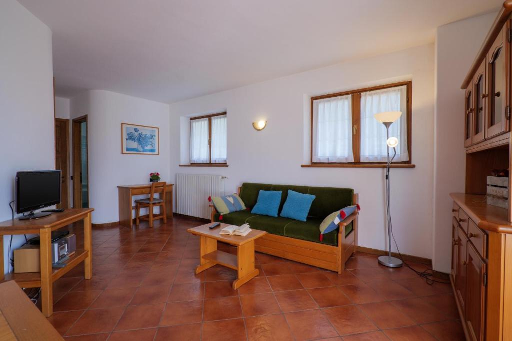 salon z zieloną kanapą i telewizorem w obiekcie Villa Palma w mieście Colico