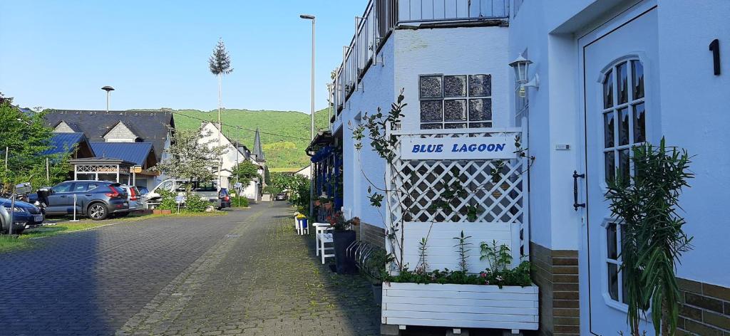 um edifício branco com uma porta ao lado de uma rua em Blue Lagoon em Nehren