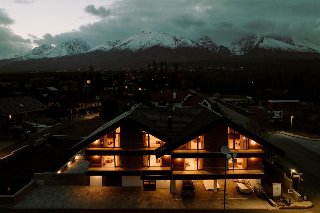 a night view of a building with mountains in the background at Villa Greystone in Nová Lesná