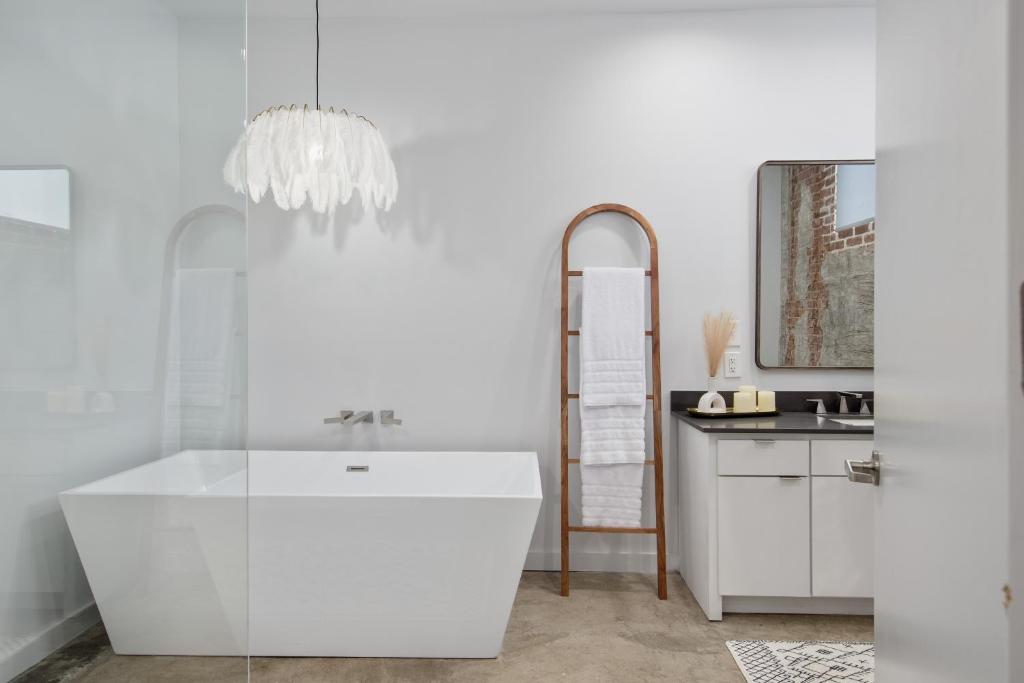 a white bathroom with a sink and a mirror at The Cypress Flats in Lafayette