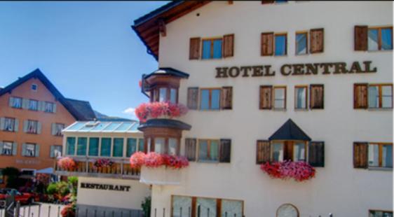 un hôtel avec des fleurs sur le côté d'un bâtiment dans l'établissement Hotel Central, à Obersaxen