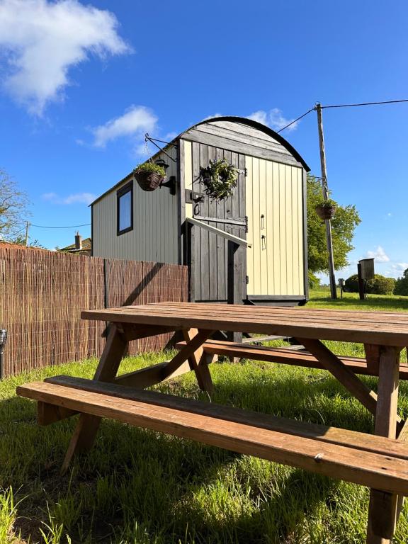 une table de pique-nique avec une petite maison en haut dans l'établissement The Hideaway, à Fakenham