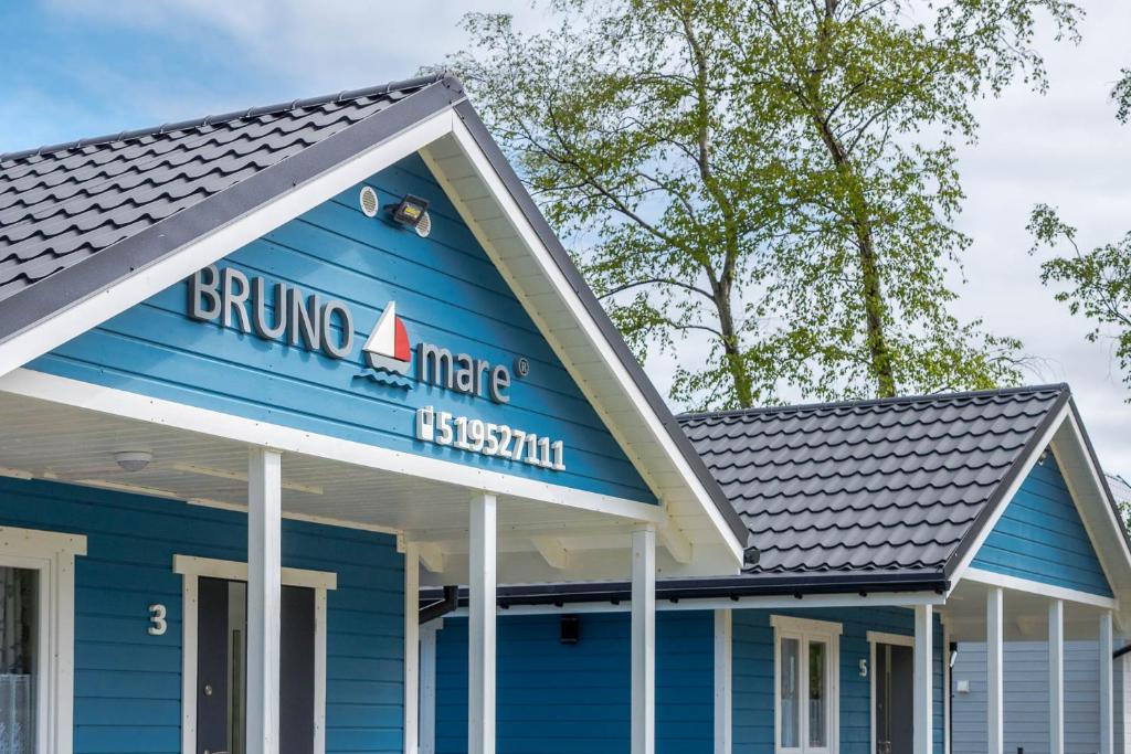 Um edifício azul com um cartaz que lê o brunch dentro de nós sushi. em Domki Bruno Mare em Bobolin
