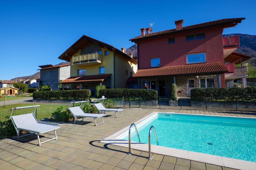 a swimming pool in front of a house at Residence Girasole Casa Rossa A in Colico