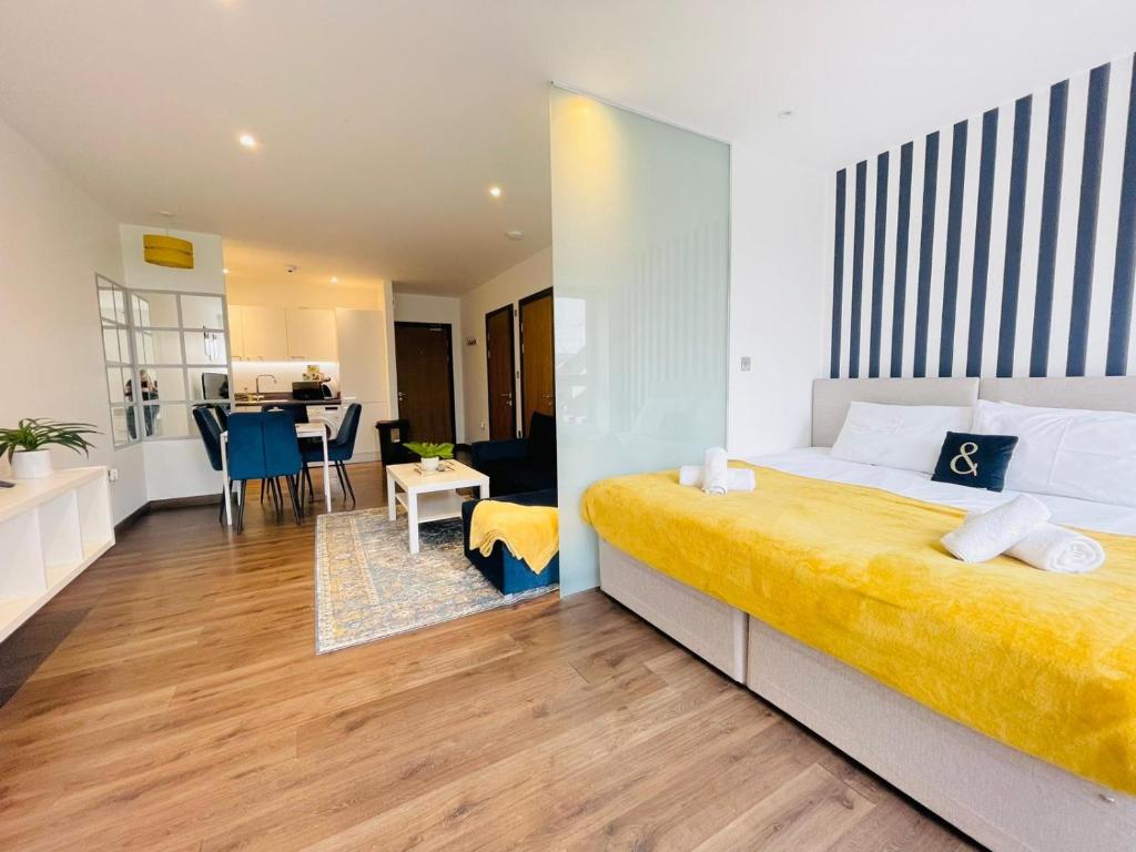 1 dormitorio con 1 cama grande y comedor en Park Street Apartment Luton by Hostaguest, en Luton