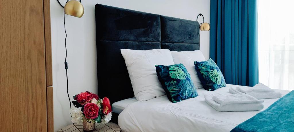 Schlafzimmer mit einem Bett mit blauen und weißen Kissen in der Unterkunft Cosmopolitan Apartament z bezpłatnym, prywatnym parkingiem w hali garażowej in Toruń