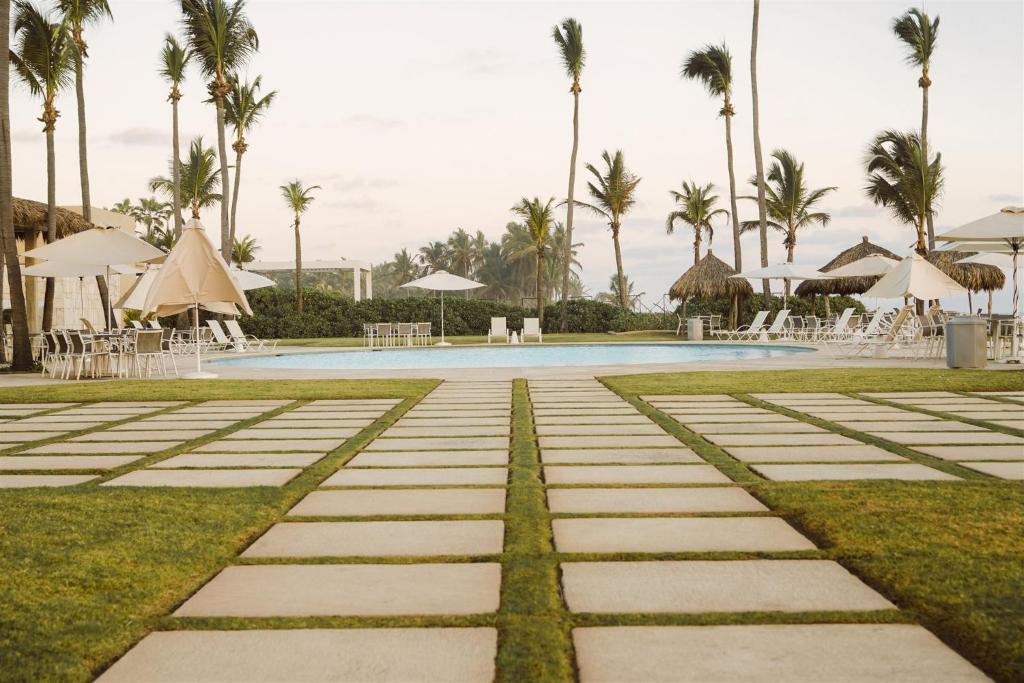 a pool at a resort with palm trees at Hotel Tres Vidas Acapulco in Barra Vieja