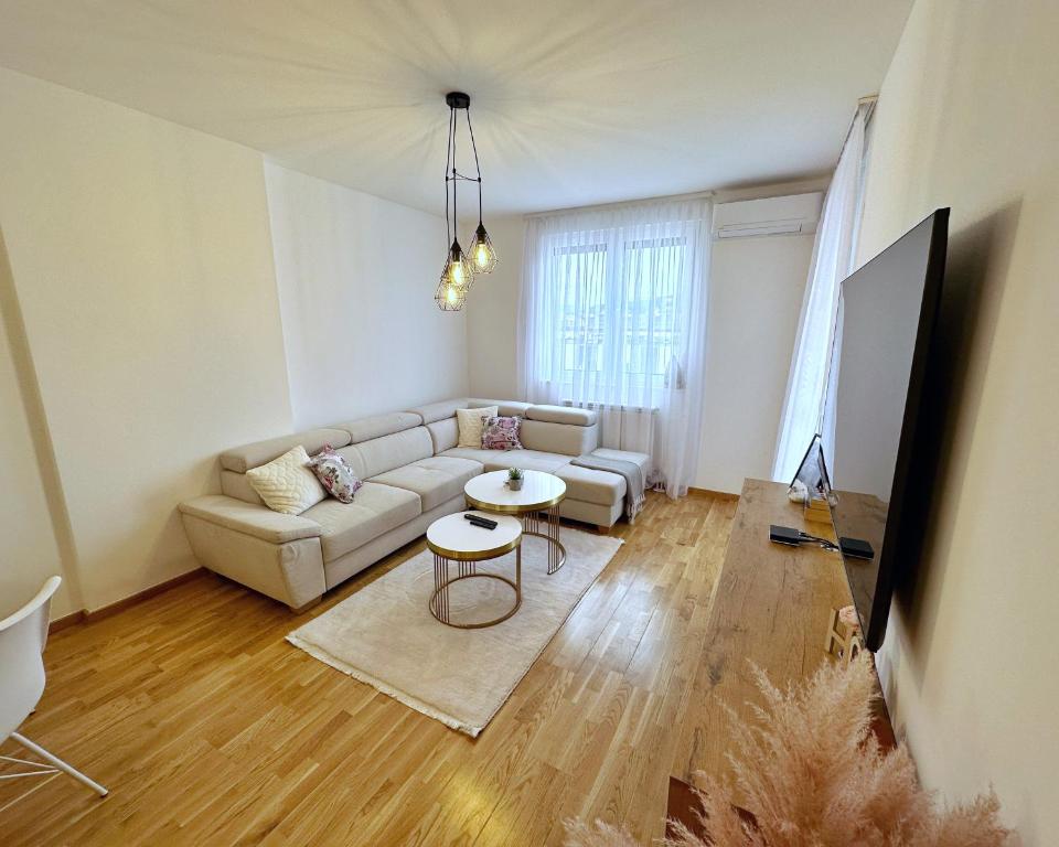 uma sala de estar com um sofá e uma mesa em Apartment Hera with private garage em Lukavica