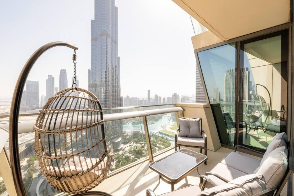 a balcony with a swing and a chair on a building at LARBI Breathtaking Burj and Fountain View Luxurious 2 Bed in Dubai