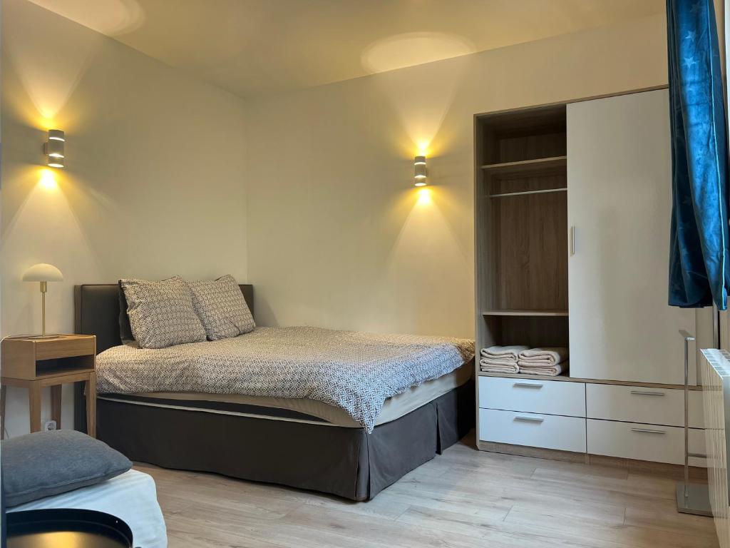 - une petite chambre avec un lit et un placard dans l'établissement Suite Junior indépendante, à Paris
