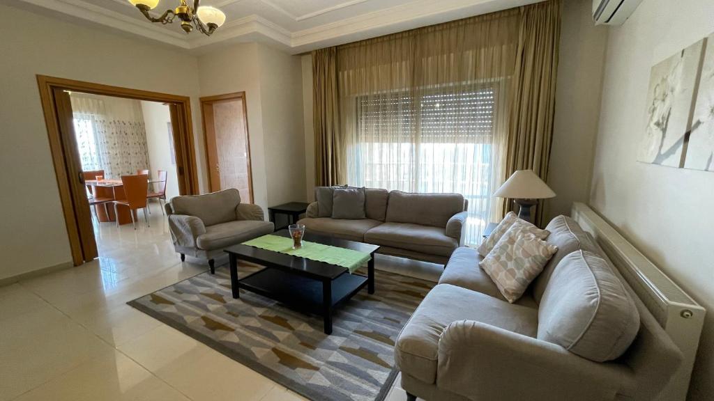 a living room with a couch and a coffee table at Abdoun Apartment in Amman