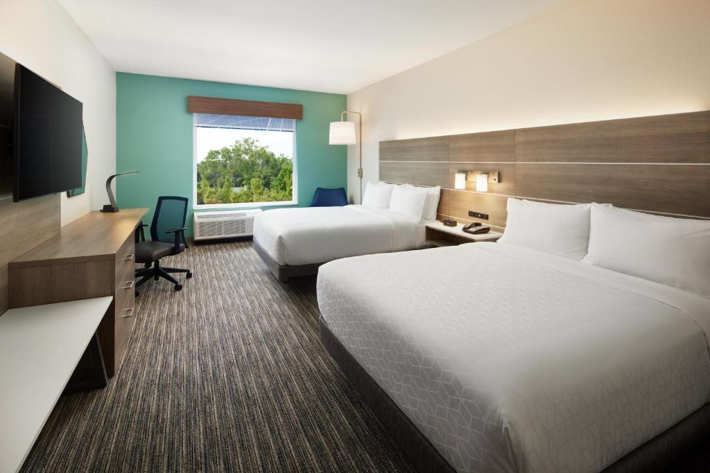 a hotel room with two beds and a desk at Holiday Inn Express & Suites Gulf Breeze - Pensacola Area by IHG in Gulf Breeze