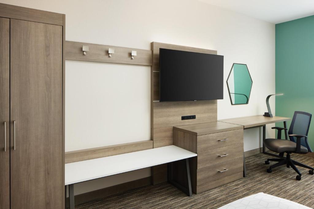 an office with a tv and a desk with a chair at Holiday Inn Express & Suites Gulf Breeze - Pensacola Area by IHG in Gulf Breeze