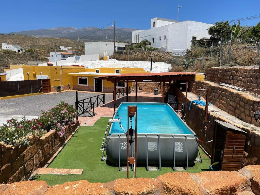 ein Schwimmbad in der Mitte eines Gartens in der Unterkunft Casa Cueva Los Mansos in Santa Cruz de Tenerife