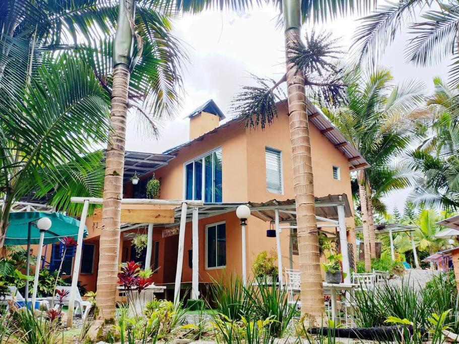 uma casa com palmeiras em frente em Estancia Sonrisas de Ángeles em Constanza