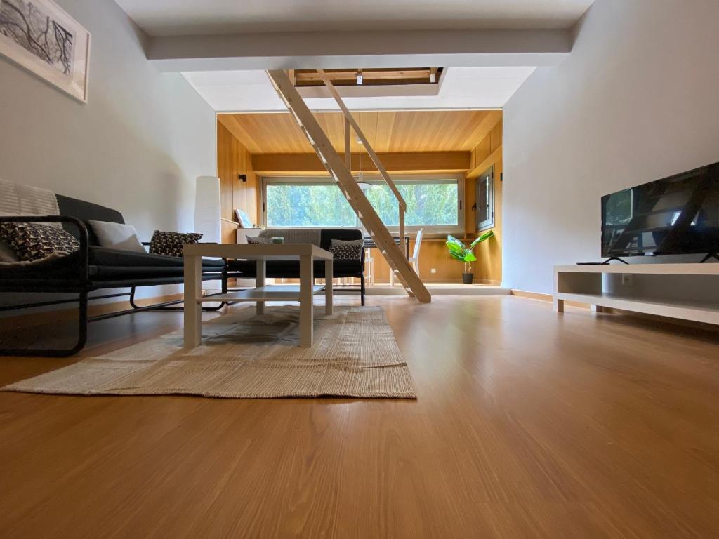 sala de estar con mesa y TV en Apartamento Duplex en La Molina, en Alp