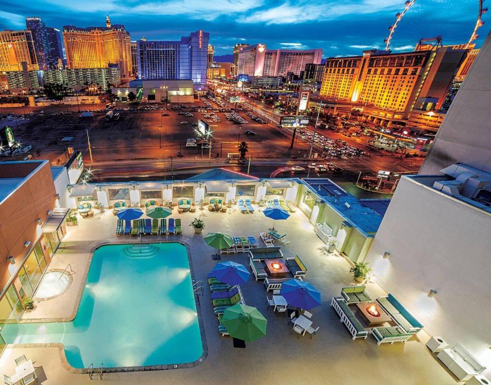 een zwembad met parasols en 's nachts een stad bij Ultimate Las Vegas Getaway One Bedroom Suite with Balcony, Kitchen, Gym, Pool & Free Parking in Las Vegas