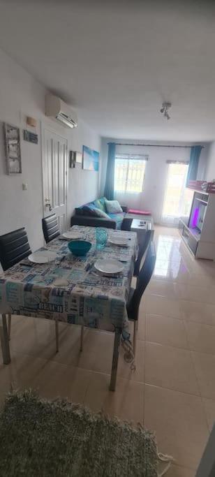 salon ze stołem i kanapą w obiekcie Bungalow avec piscine w mieście Torrevieja