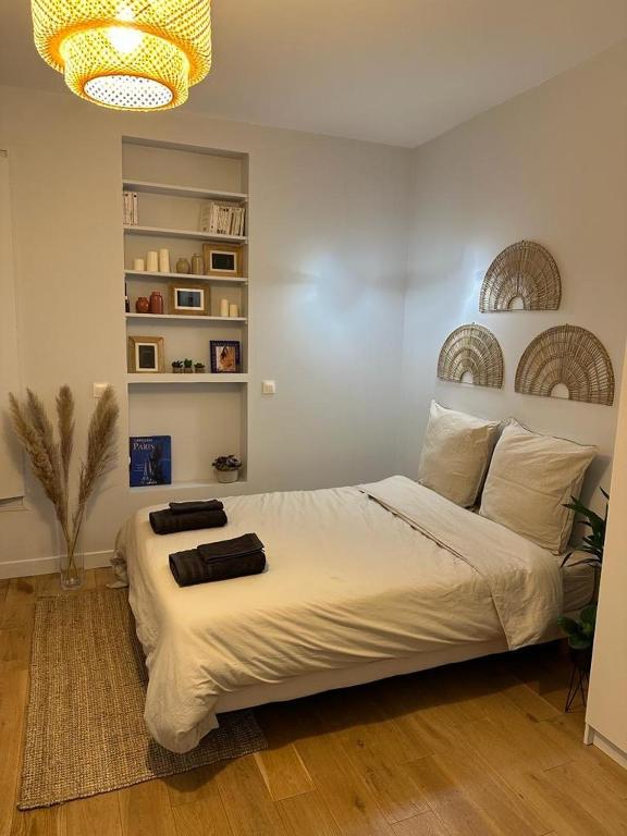 une chambre avec un grand lit blanc avec un lustre dans l'établissement Studio -Champs Élysées, à Paris