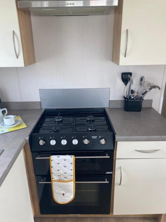 a kitchen with a black stove top oven at Cosy holiday home at Romney Sands in New Romney