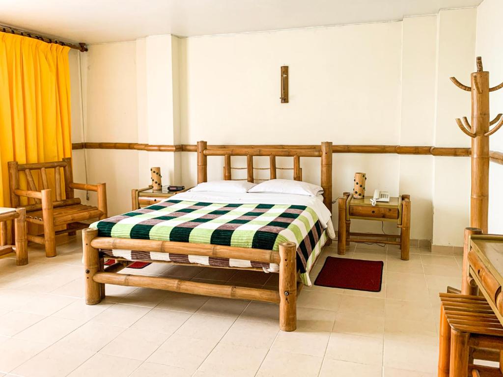 a bedroom with a wooden bed in a room at Hotel Casa Yaripa in Manizales