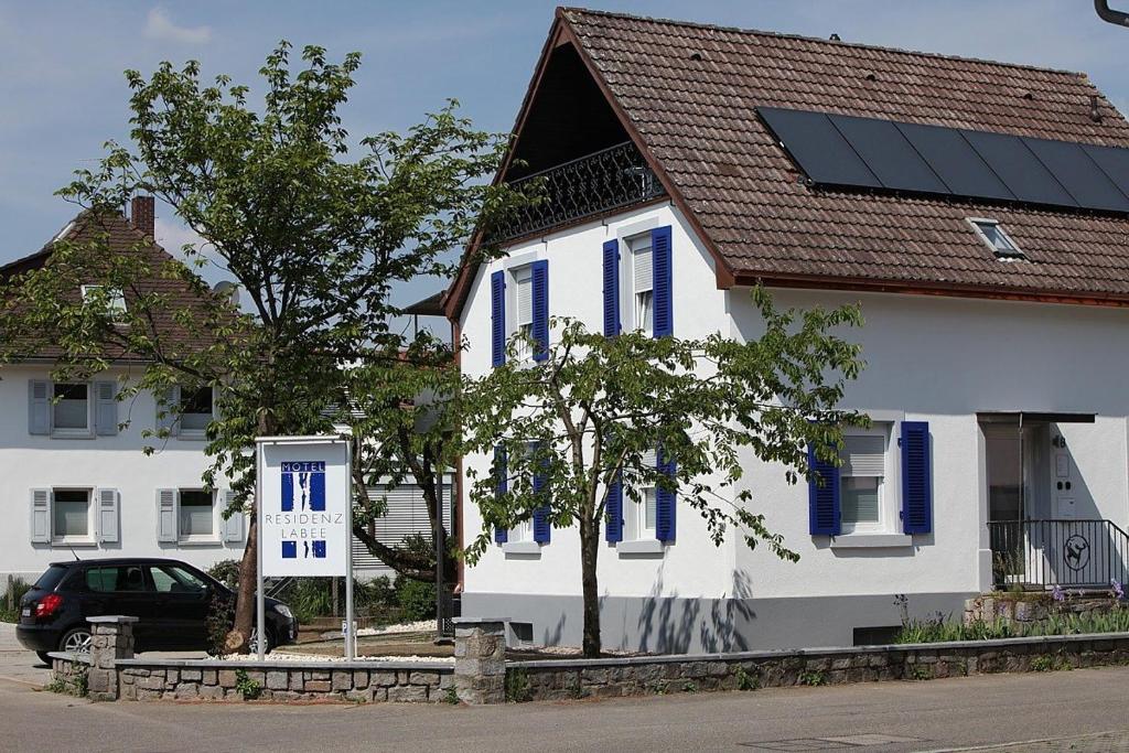 ein weißes Haus mit einem Sonnenkollektor auf dem Dach in der Unterkunft Residenz Labee in Weil am Rhein