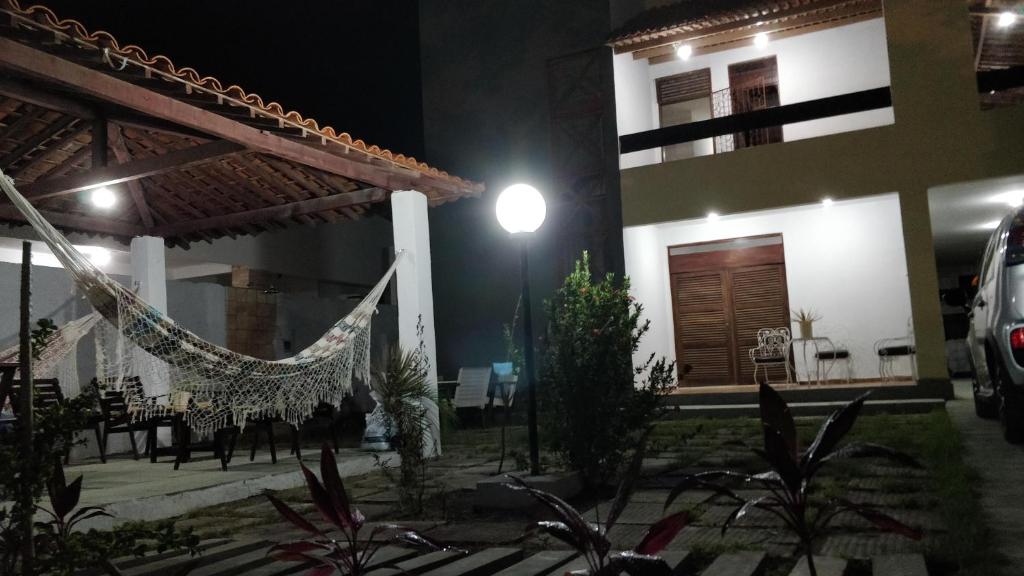 a house with a hammock in front of it at Casarão na Praia de Camboinha a 250 metros do mar in Cabedelo