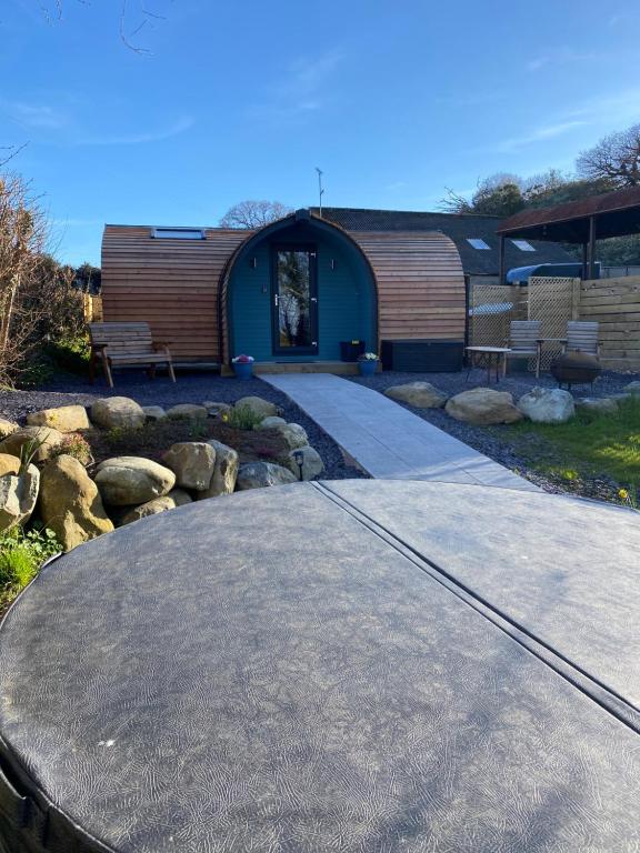 un petit bâtiment avec un banc et une passerelle dans l'établissement Cwt y Gwenyn Glamping Pod, à Conwy