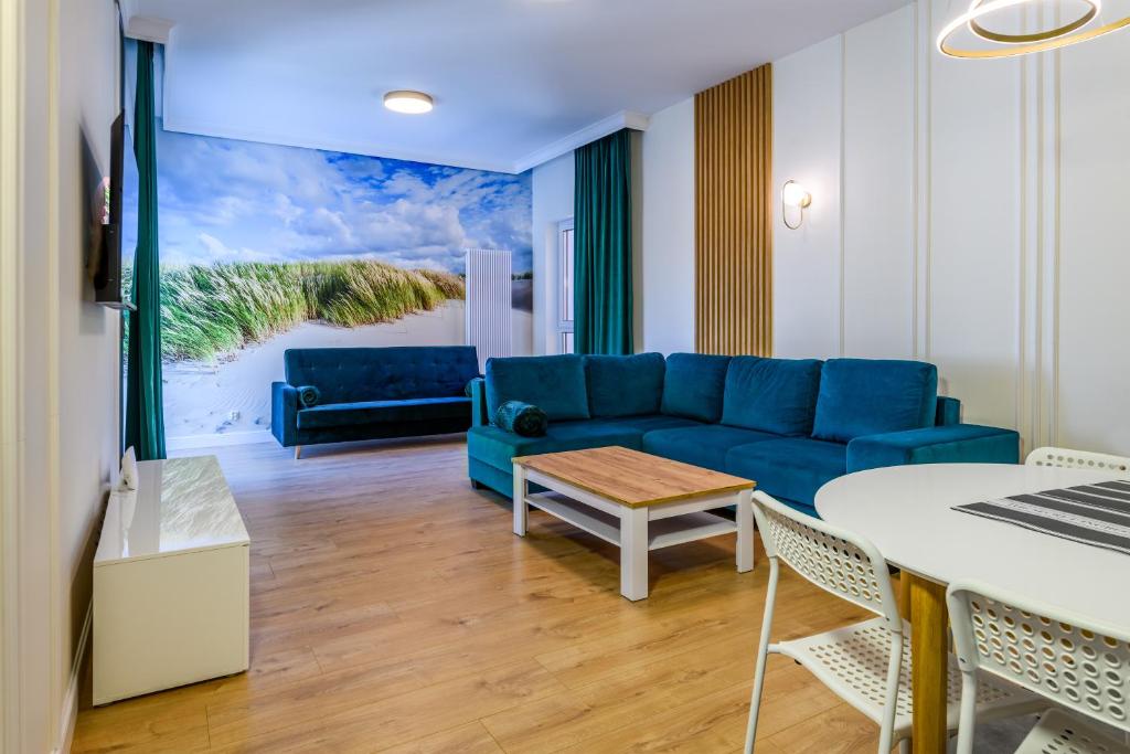 a living room with a blue couch and a table at Apartament Double Rest 15 in Jastrzębia Góra
