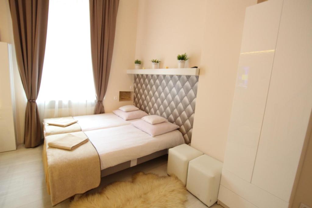 a small bedroom with two beds and a window at Rainbow Apartments 2 in Krakow
